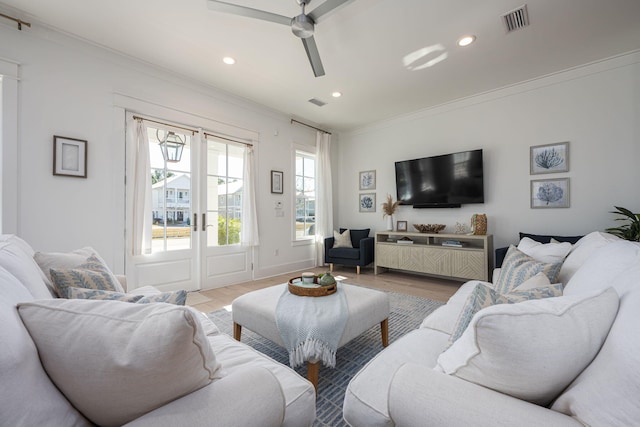 living room featuring ceiling fan, light hardwood / wood-style floors, and crown molding