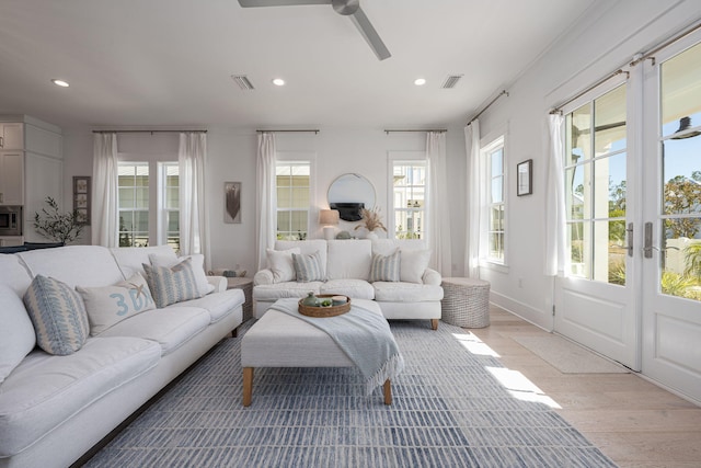 living room featuring ceiling fan, a healthy amount of sunlight, and light hardwood / wood-style flooring