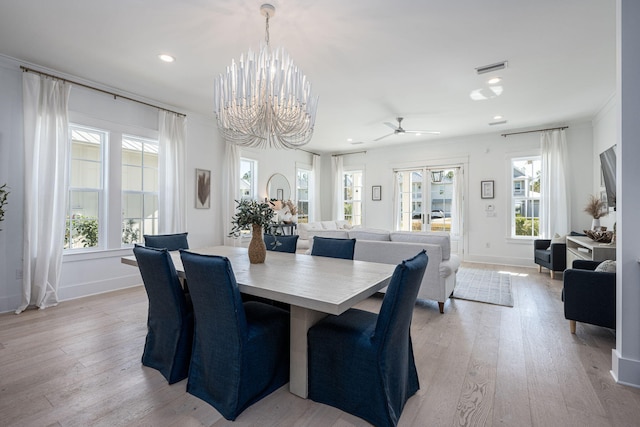 dining room featuring ceiling fan with notable chandelier, light wood-type flooring, and ornamental molding