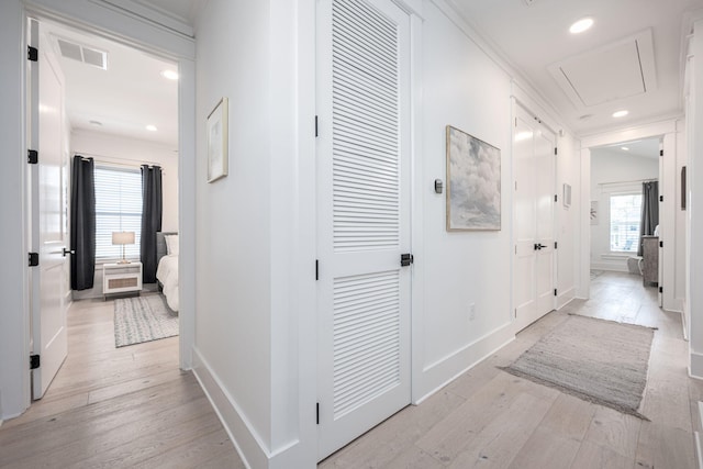 hallway featuring crown molding and light hardwood / wood-style floors