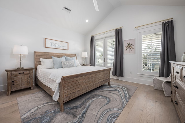 bedroom featuring vaulted ceiling, french doors, access to outside, and light hardwood / wood-style flooring