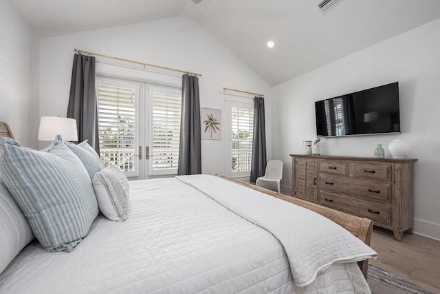 bedroom featuring hardwood / wood-style flooring, vaulted ceiling, and access to exterior