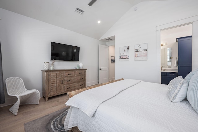 bedroom featuring hardwood / wood-style flooring, ceiling fan, connected bathroom, and high vaulted ceiling