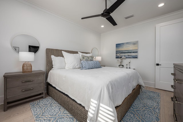 bedroom with light hardwood / wood-style flooring, ceiling fan, and crown molding