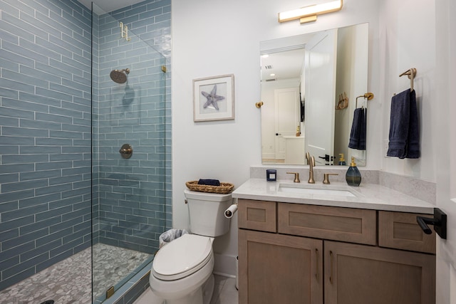 bathroom with a tile shower, vanity, and toilet