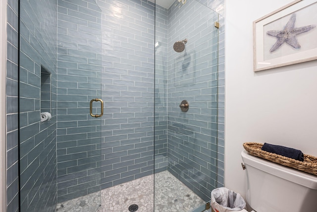 bathroom with a shower with door and toilet