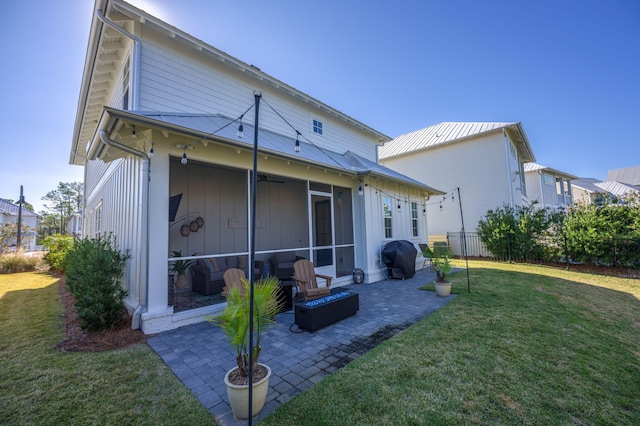 back of property with a lawn, a sunroom, and a patio area