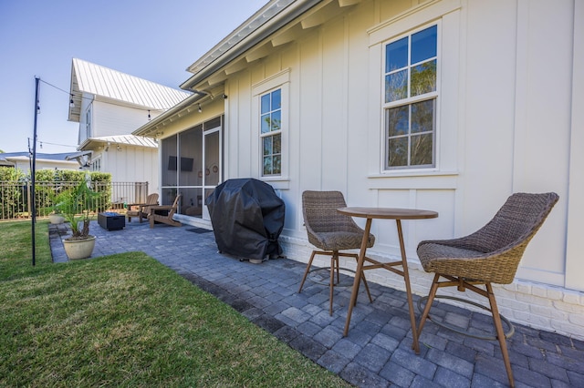 view of patio with a sunroom and a grill