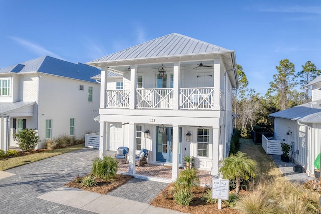 view of front of home with ceiling fan, a garage, covered porch, and a balcony