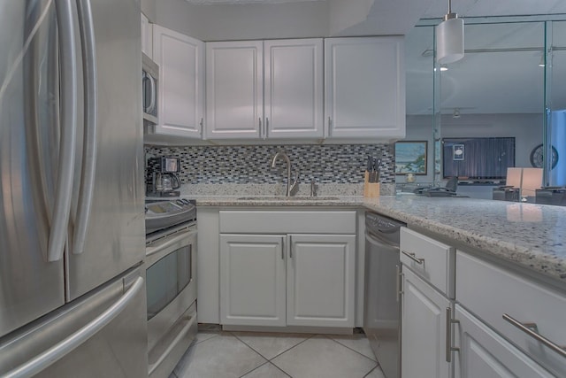 kitchen featuring stainless steel appliances, sink, white cabinets, hanging light fixtures, and light tile patterned flooring