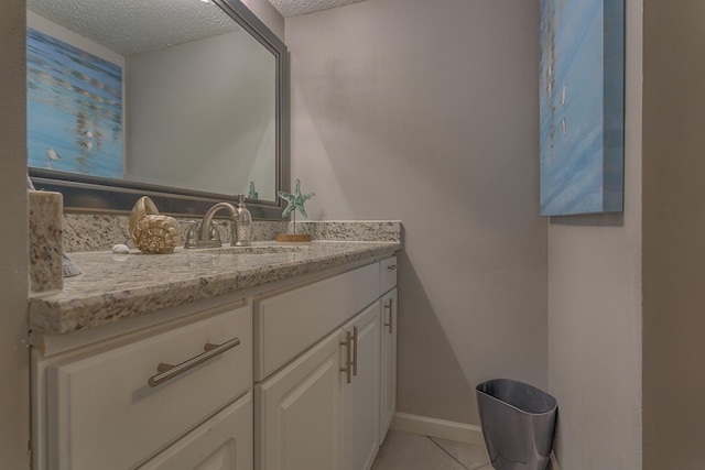 bathroom with tile patterned floors, vanity, and a textured ceiling