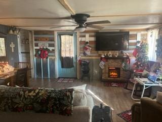 living room featuring ceiling fan, a fireplace, and hardwood / wood-style flooring