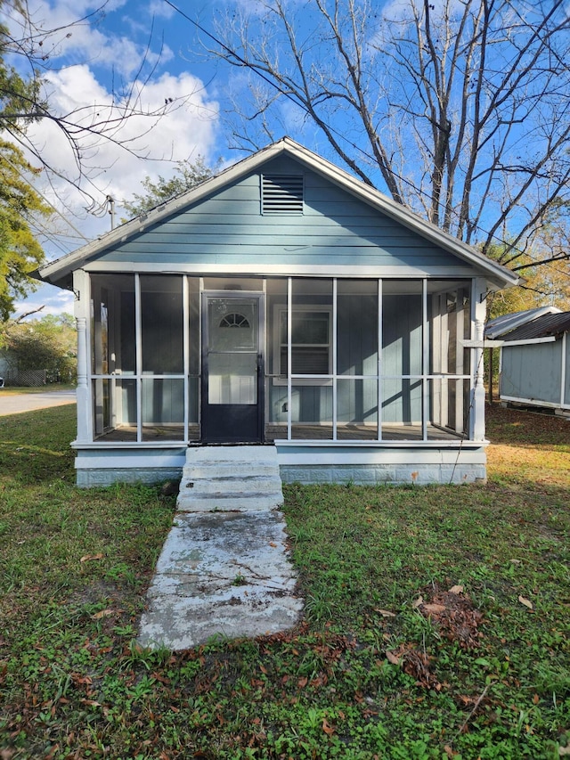 back of house featuring a sunroom and a yard