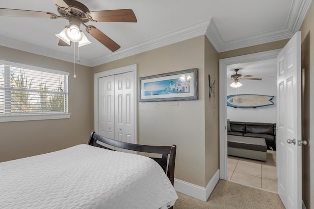 tiled bedroom with crown molding, ceiling fan, and a closet