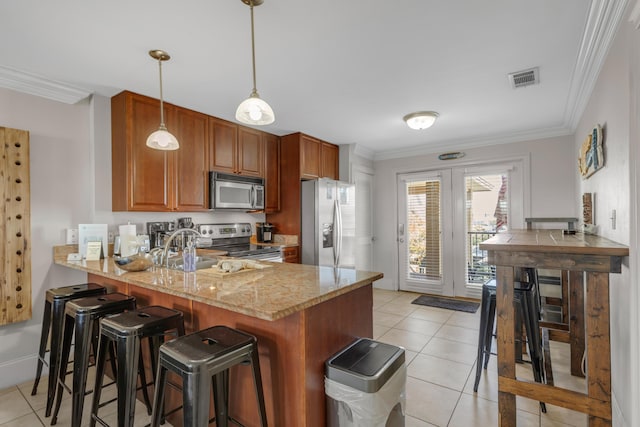 kitchen featuring light stone counters, light tile patterned floors, kitchen peninsula, pendant lighting, and stainless steel appliances