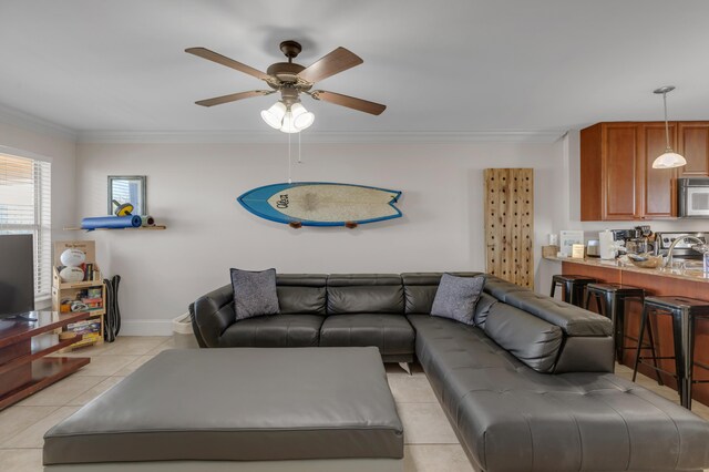 living room with sink, crown molding, ceiling fan, and light tile patterned flooring