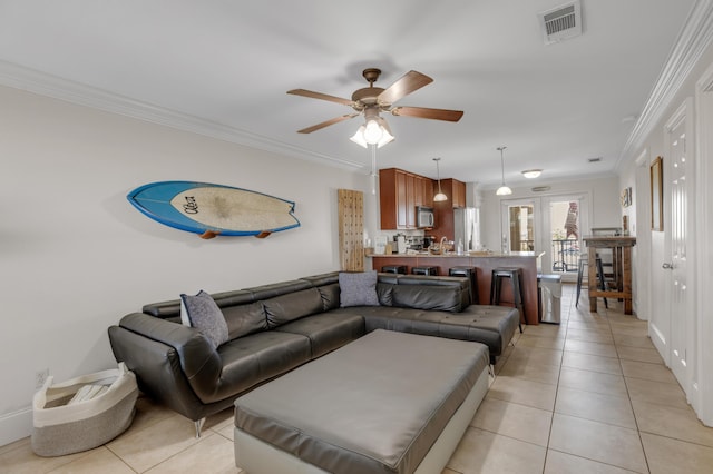 living room with ornamental molding, light tile patterned floors, and ceiling fan