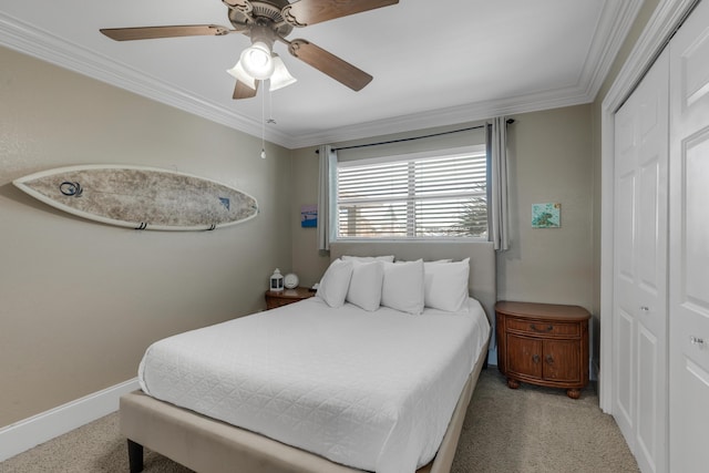 bedroom with ornamental molding, light colored carpet, ceiling fan, and a closet