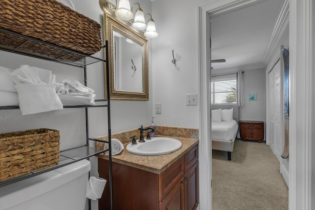 bathroom with crown molding, vanity, and toilet