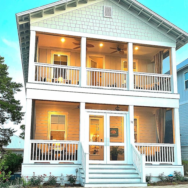 rear view of property with ceiling fan, a porch, and a balcony