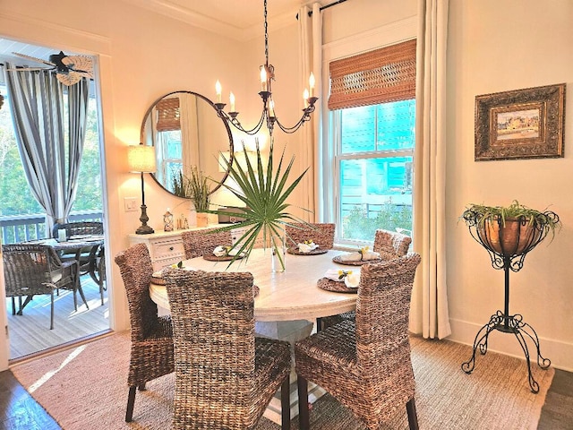 dining area with hardwood / wood-style floors, crown molding, and an inviting chandelier