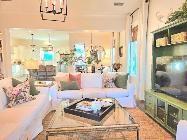 living room with ornamental molding and a chandelier