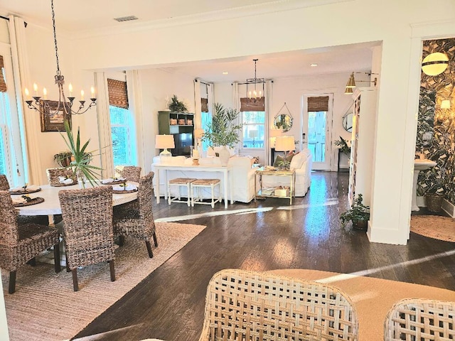 dining space featuring ornamental molding, a chandelier, and hardwood / wood-style floors