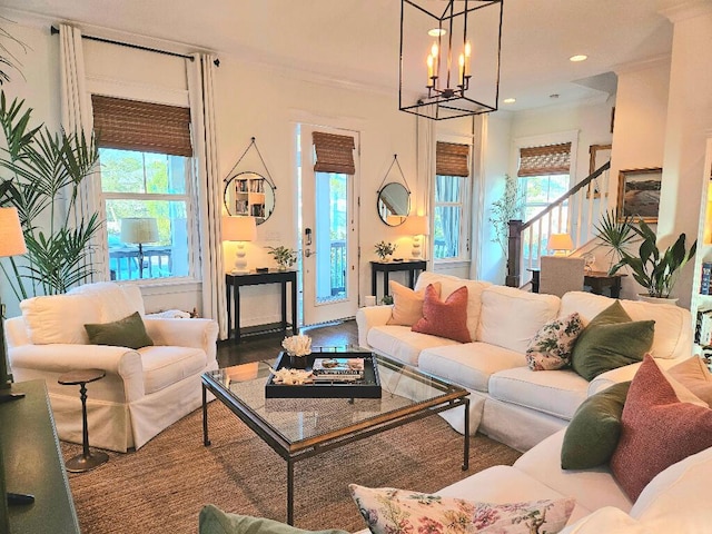 living room featuring an inviting chandelier, wood-type flooring, and ornamental molding