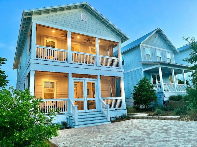 rear view of house with ceiling fan, a balcony, and a porch