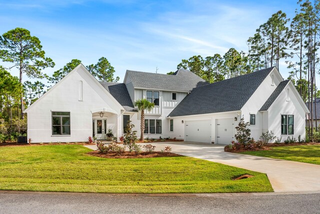 view of front of house featuring a garage, central AC unit, and a front lawn