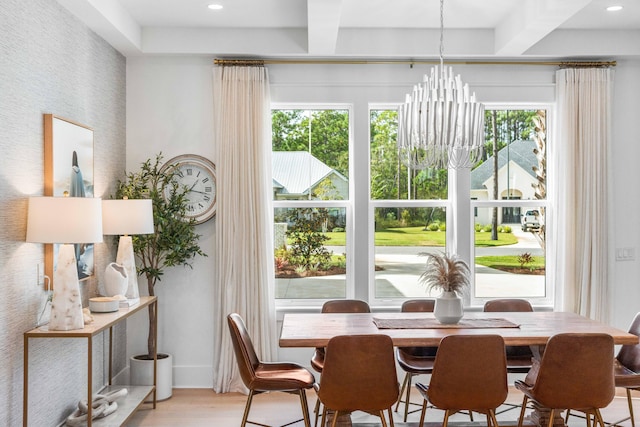 dining room with a notable chandelier, beamed ceiling, and light hardwood / wood-style flooring