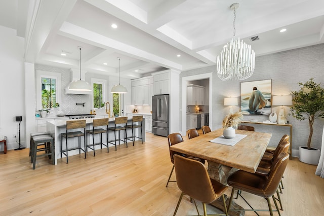 dining room featuring beamed ceiling, coffered ceiling, a chandelier, and light wood-type flooring