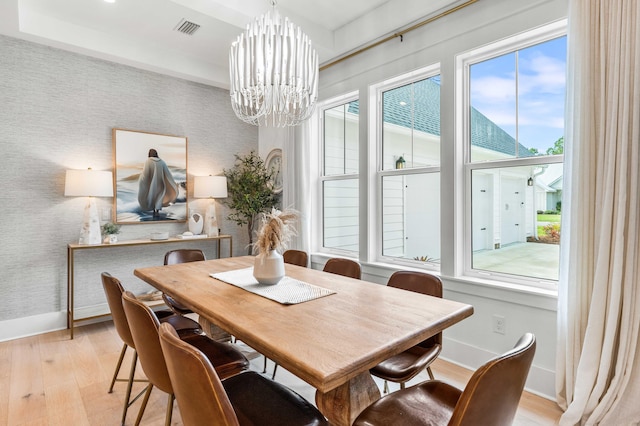 dining space featuring light hardwood / wood-style floors and a chandelier