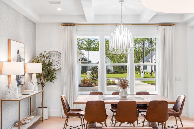 dining room with an inviting chandelier, light hardwood / wood-style floors, and beamed ceiling