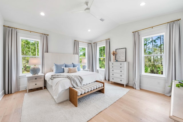 bedroom featuring lofted ceiling, ceiling fan, light hardwood / wood-style floors, and multiple windows