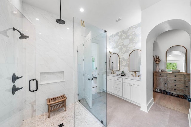 bathroom with a shower with door and vanity