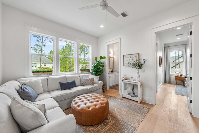 living room with light wood-type flooring and ceiling fan