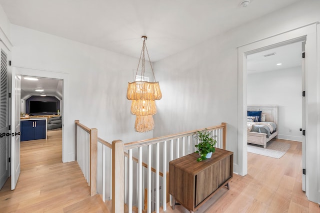 hallway featuring a notable chandelier and light wood-type flooring