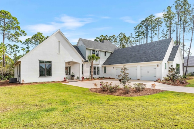 view of front of home featuring central AC, a front yard, and a garage