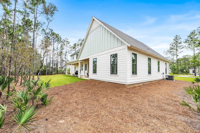 489 Hideaway Cir, Santa Rosa Beach, FL 32459 - rear view of property featuring board and batten siding, a lawn, roof with shingles, and central AC