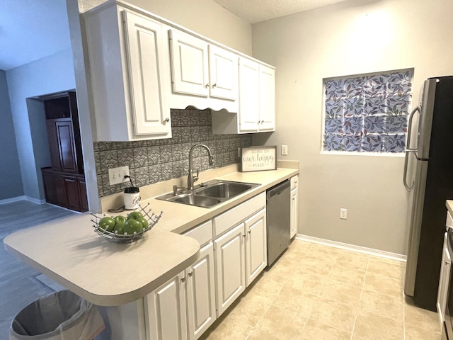 kitchen with a kitchen breakfast bar, stainless steel appliances, white cabinetry, and sink