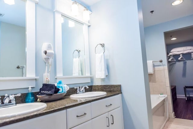 bathroom featuring a tub, vanity, and wood-type flooring