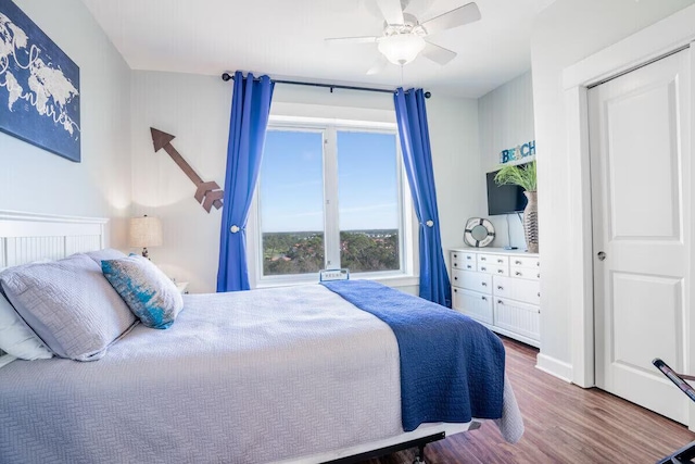 bedroom with hardwood / wood-style flooring, ceiling fan, and a closet