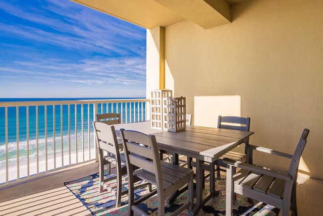 balcony featuring a view of the beach and a water view