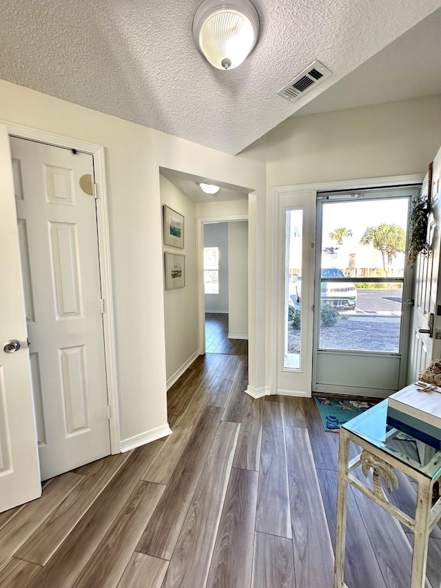 doorway to outside with hardwood / wood-style flooring and a textured ceiling