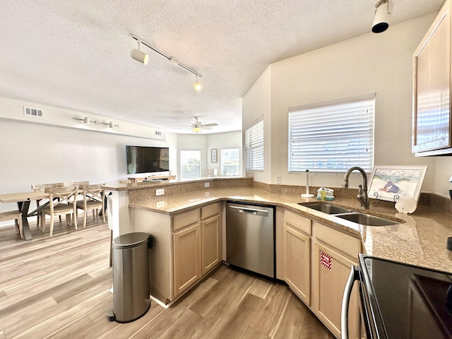 kitchen with ceiling fan, sink, stainless steel dishwasher, a textured ceiling, and light wood-type flooring