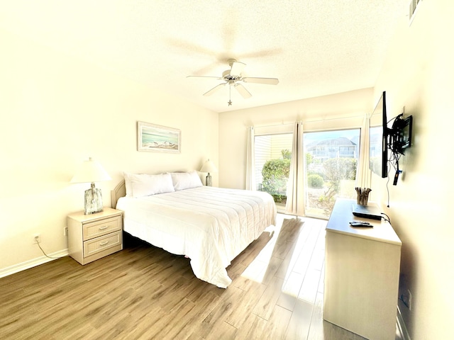 bedroom with ceiling fan, a textured ceiling, and light wood-type flooring