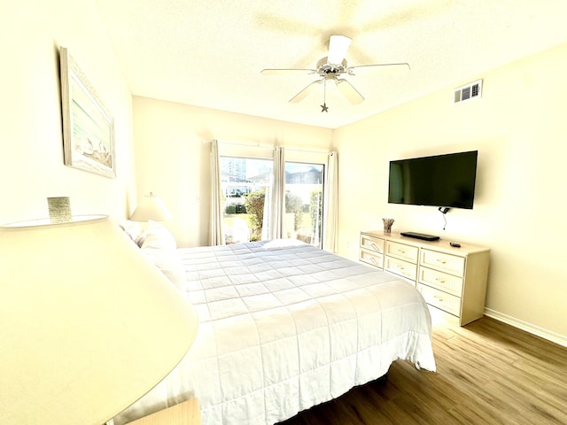 bedroom featuring wood-type flooring, a textured ceiling, and ceiling fan