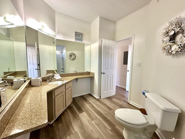 bathroom featuring vanity, hardwood / wood-style floors, a textured ceiling, and toilet