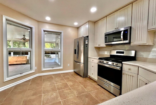 kitchen featuring ceiling fan, light tile patterned flooring, backsplash, and appliances with stainless steel finishes